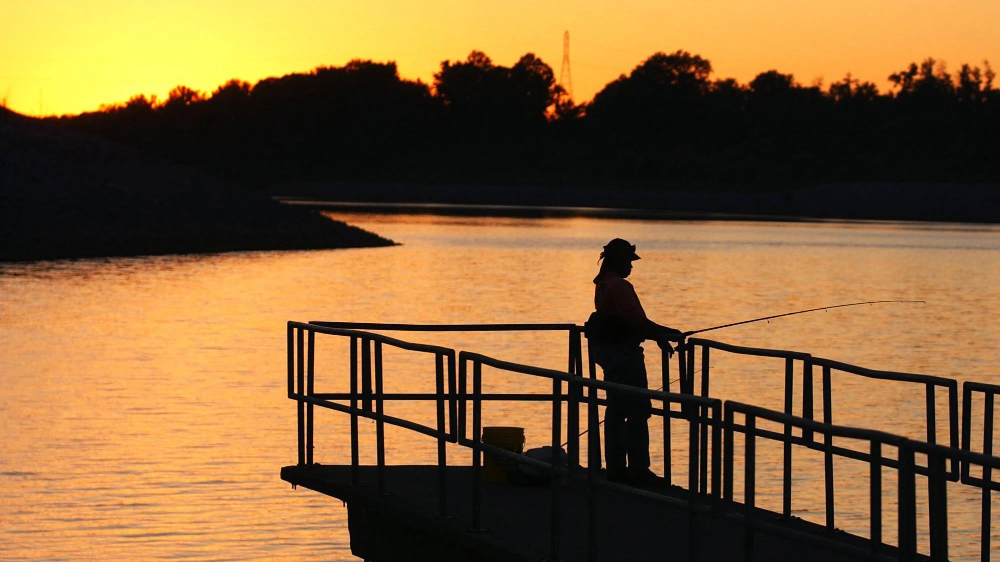someone fishing from a pier at sunset in Tuscaloosa